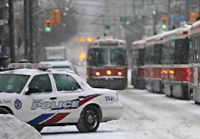 Streetcars driving past a police car