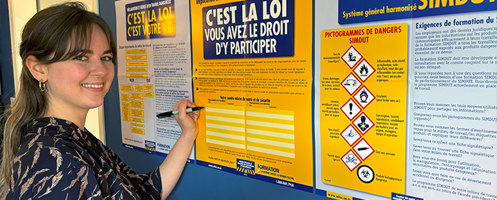 Worker reviews WHSC health and safety posters on the right to know, right to participate and right to refuse unsafe work