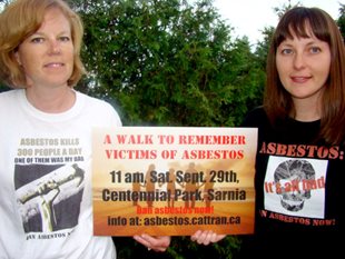 Activists hold a sign promoting a 'Walk to Remember Victims of Asbestos' event in Sarnia