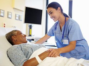 Ontario nurse smiles while caring for a patient