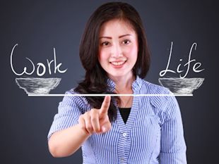 Woman pointing at a scale that has 'work' on on side and 'life' on the other