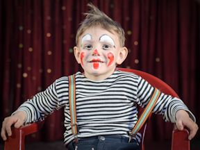 Child performer wearing clown makeup