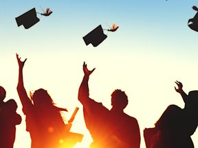 Graduates throw their academic caps in the air