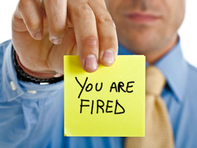 Worker holds a note that says 'You are fired'