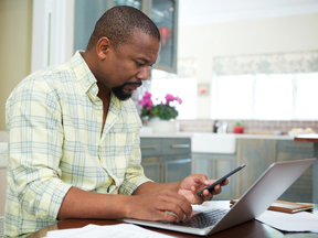 Worker working from home on phone and laptop at same time