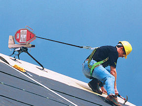 Worker working on a rooftop while wearing a safety harness