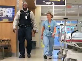 Nurse walks through hospital with security guard