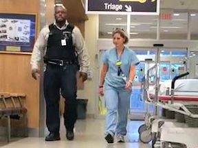 Nurse walks through hospital with security guard
