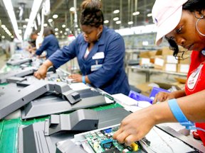 Workers work on installing the motherboard to a 32-inch TV